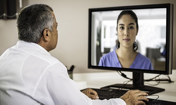 Man talking to specialist nurse via screen about prostate cancer