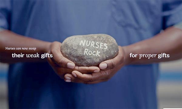 Photo of a nurse holding a large rock which says 