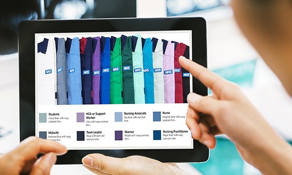 A picture of the colour uniforms chosen to represent different professions being looked at on a tablet 