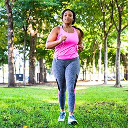 A woman jogging outdoors, which along with other forms of exercise can improve sleep quality