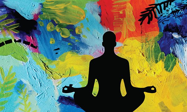  Image shows silhouette of a male meditating in lotus position against abstract background.  Wellness events such as games or creative activities ease strains and help prevent burnout.