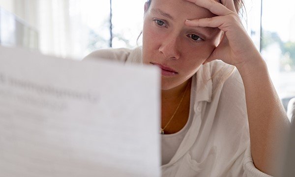 A woman looks distressed while reading a letter. One in three cancer patients treatment has been affected. Picture: iStock