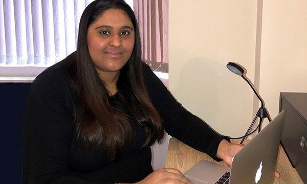 Nursing student Romi Dhillon sits at an open laptop