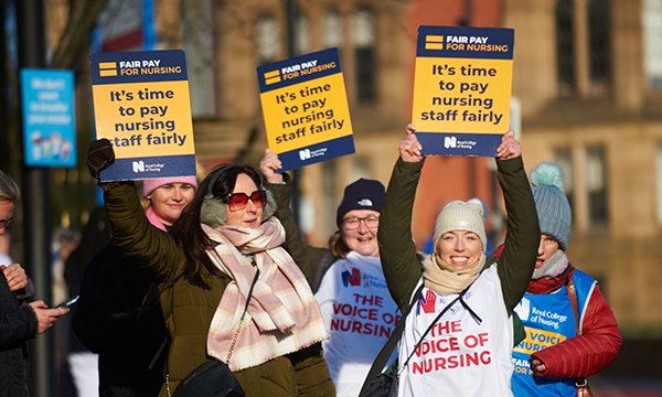 Striking NHS nurses on Sheffield picket line hold RCN pay campaign banners 