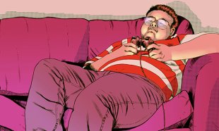 Young obese man lies on the sofa playing computer games