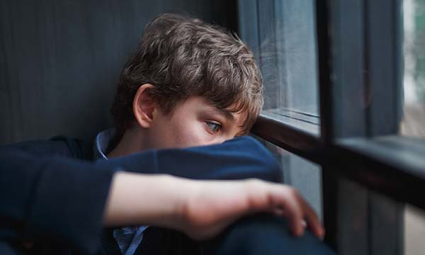 Picture shows a model depicting a depressed teenage boy sitting by a window. Learning disability and autism significantly increase the chances of having a mental health condition and are also predictive of poorer general health, a study shows.